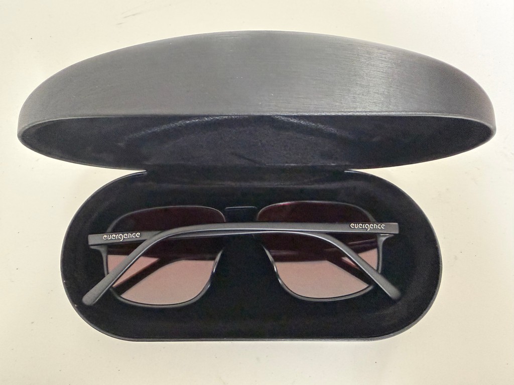 Open Jetpack Case with glasses resting inside, showing the frame and light red lenses