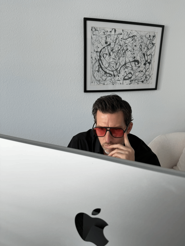 Sean Everett wearing red-lens Jetpack Glasses while working in front of a computer